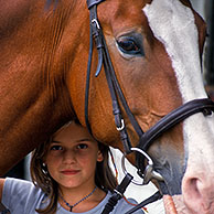 Close up of child with horse (Equus caballus) at stables, Belgium